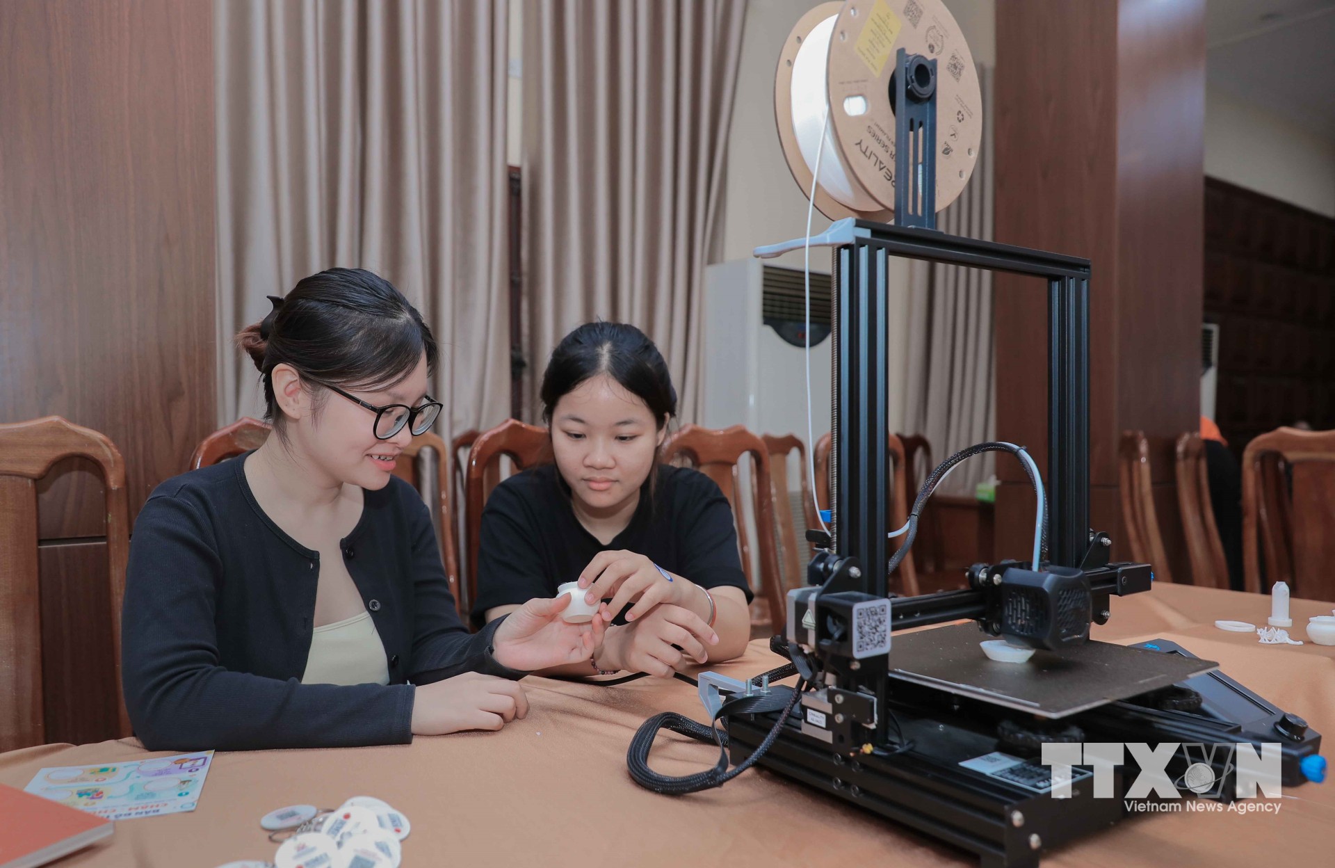Tại sự kiện, máy in 3D đang tạo ra hũ gạo tiết kiệm - hiện vật của bà Trương Thị Quế (kiều bào Thái Lan) dùng đựng gạo gửi về nước chống Pháp 1951 - 1952, biểu tượng của tình đoàn kết. (Ảnh: Phan Phương/TTXVN)